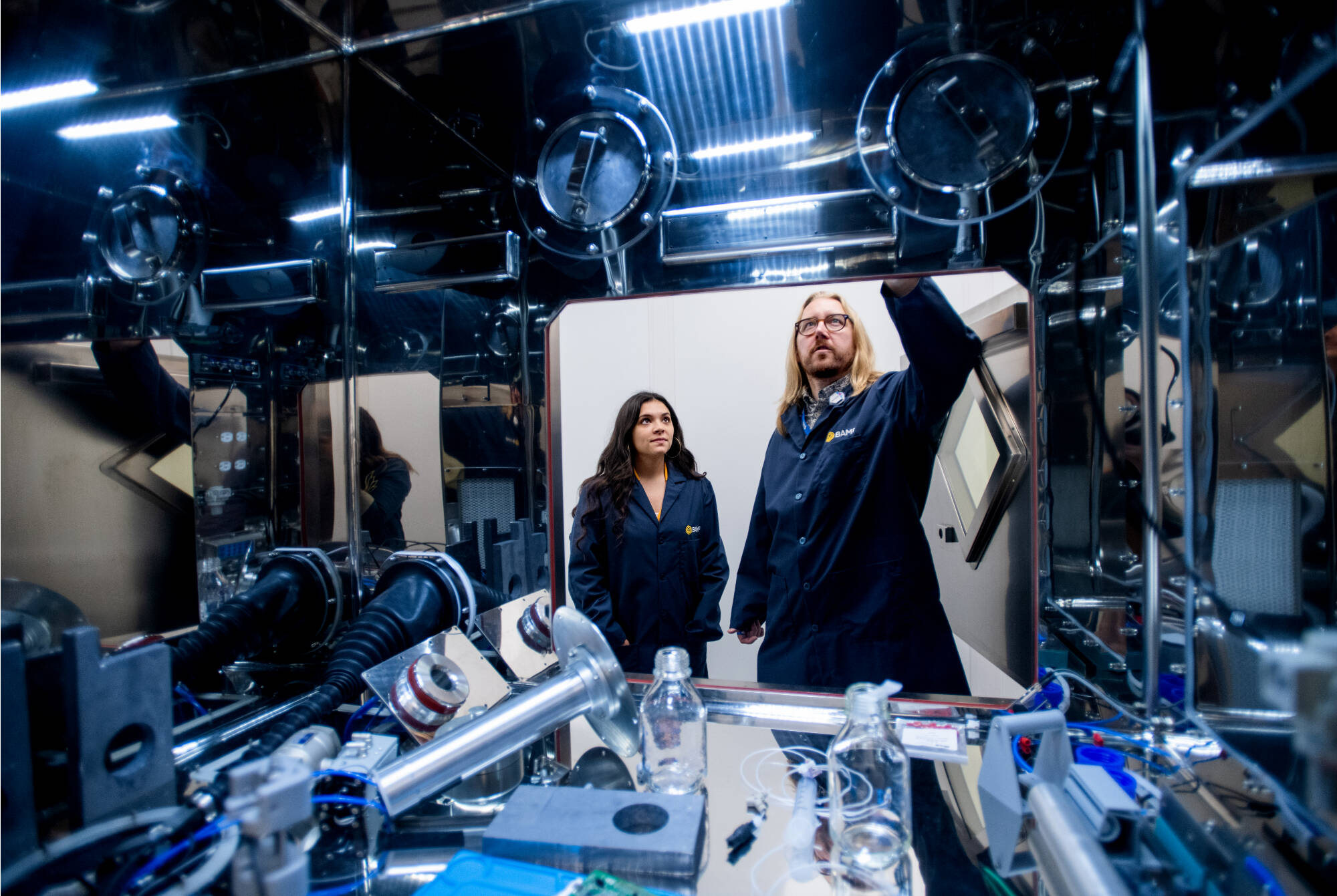 Grand Valley graduates Samantha Spurr, left, and Paul Shields, right, are pictured near a research hot cell, which allows them to work safely with radioactive material. (Photo releases on file)